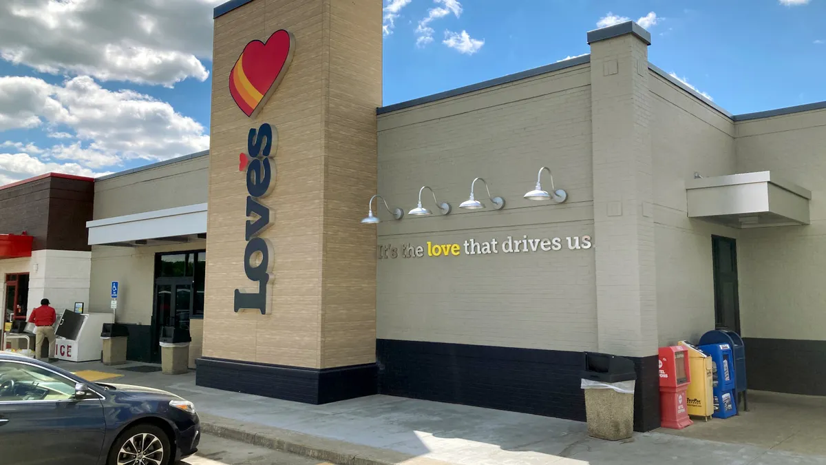 A facade of a commercial building, a sign reads, "Love's" and another reads "It's the love that drives us".