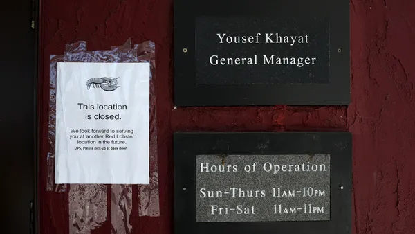 A sign on a red wall that has the name "Yousef Khayat General Manager" and another sign that says "This location is closed."