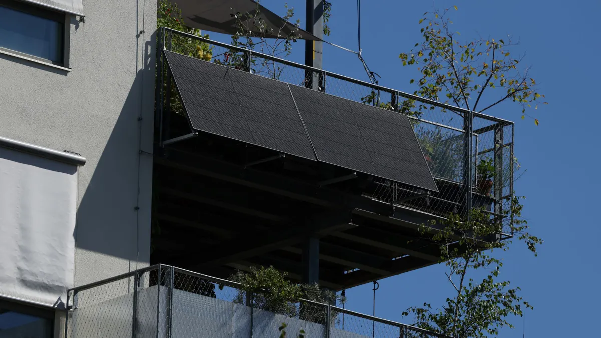 A solar panel attached to an apartment balcony.