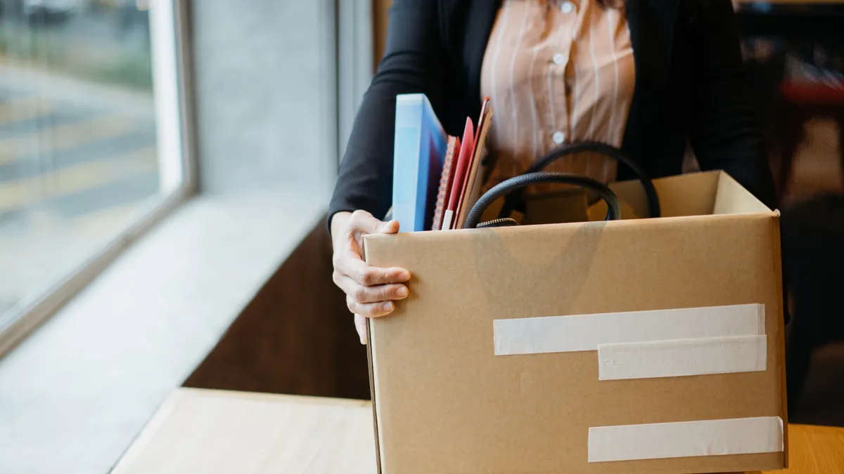 Woman holding cardboard box with personal belongings