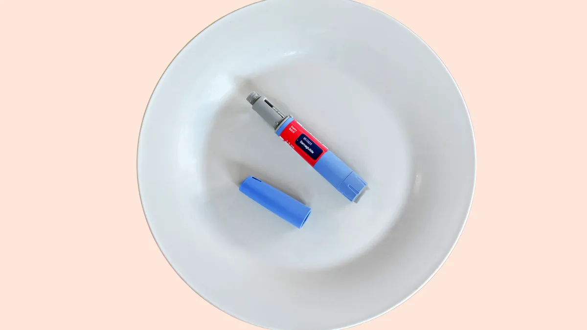 An injection pen containing the drug semaglutide lies on a white plate.