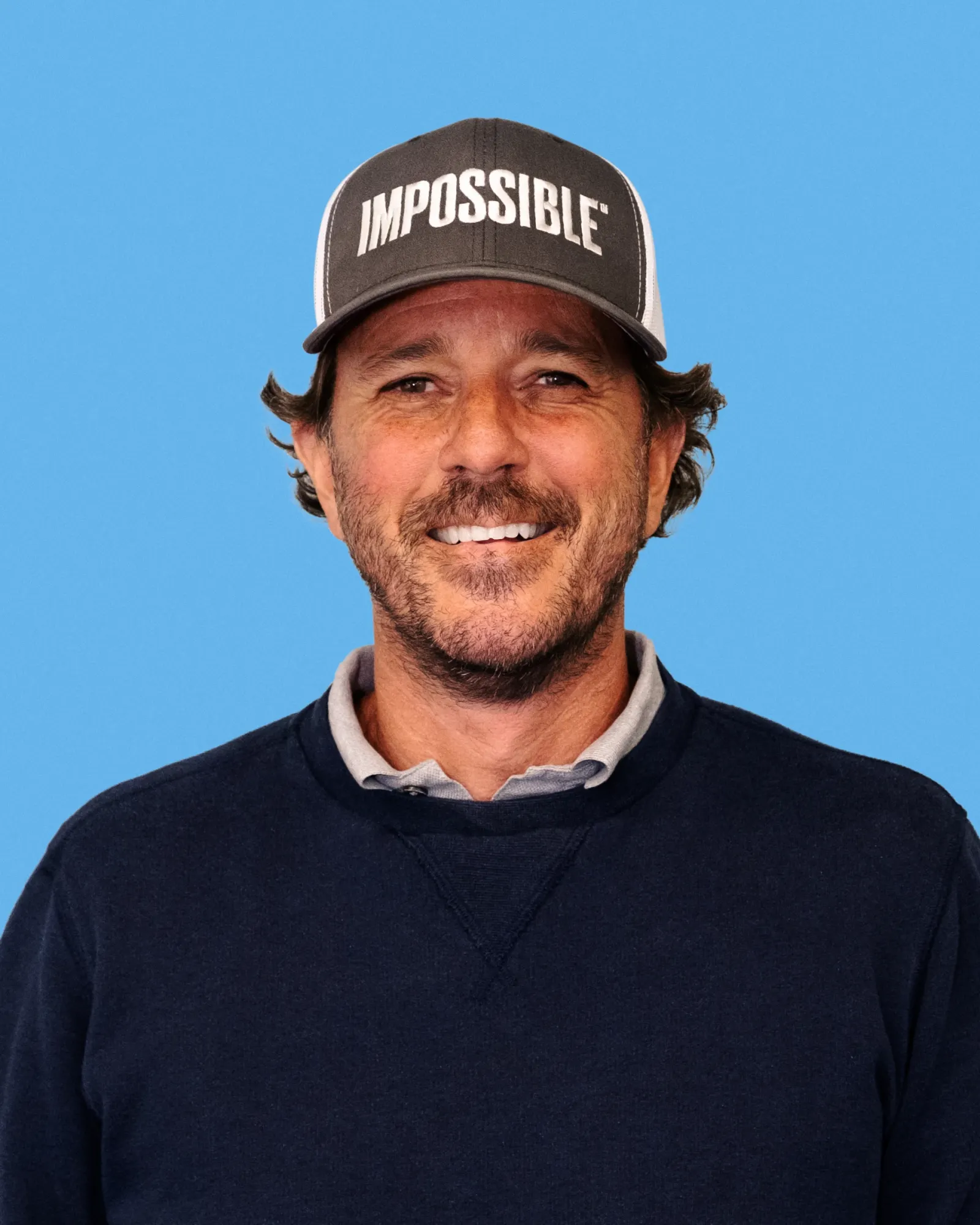 Headshot of Peter McGuinness wearing an Impossible Foods baseball cap.