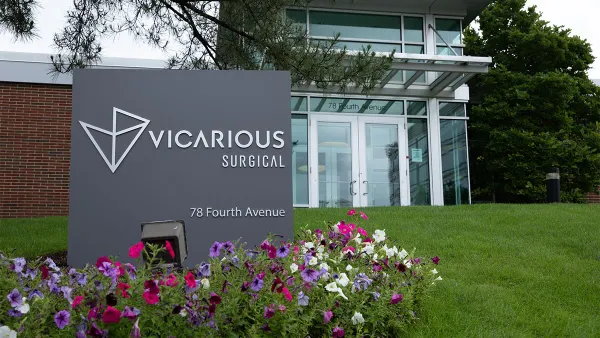 Pink and purple petunias bloom in front of the Vicarious Surgical sign at the Waltham, Massachusetts, office.