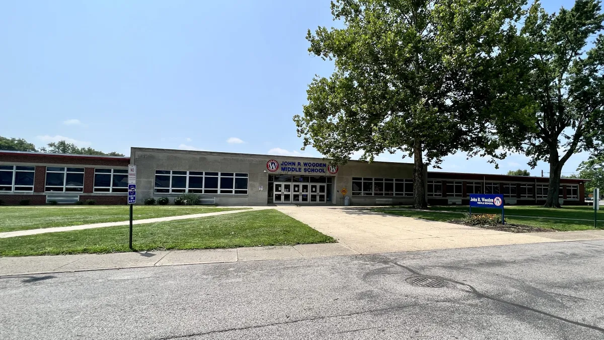 The edifice of John R. Wooden Middle School against a blue sky