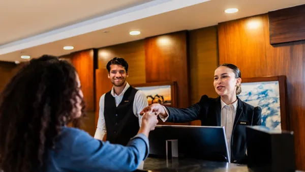 A hotel receptionist checking in guests at the front desk
