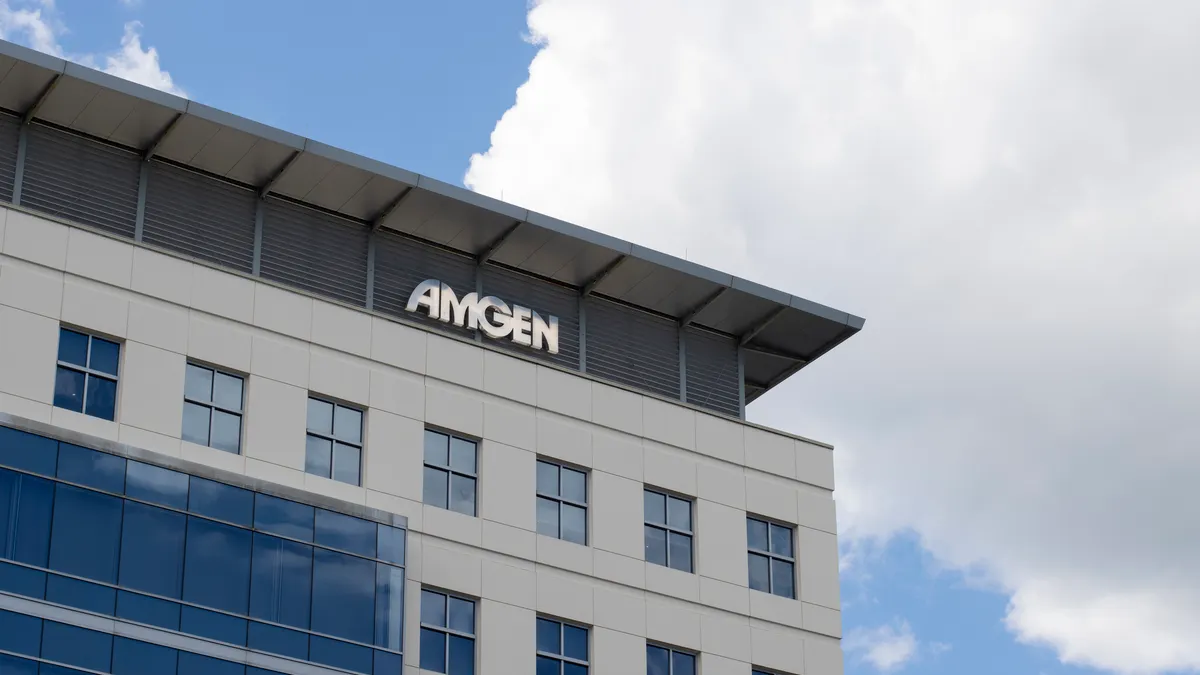 A sign spelling Amgen hangs on the side of an office building