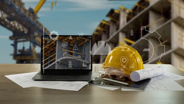 A construction helmet on a table around artistic depictions of technology.