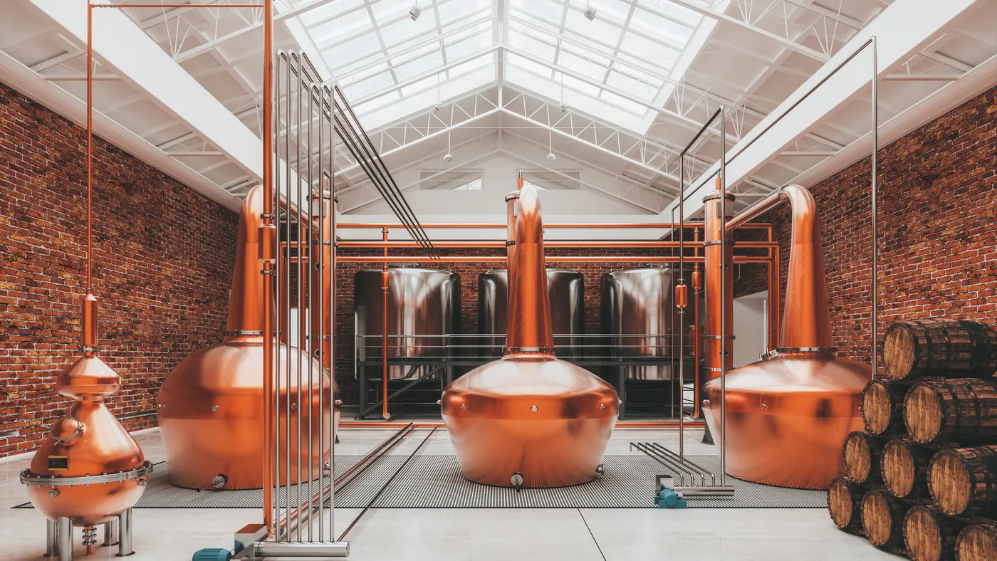 Copper whisky vats are stationed in a Scottish distillery.