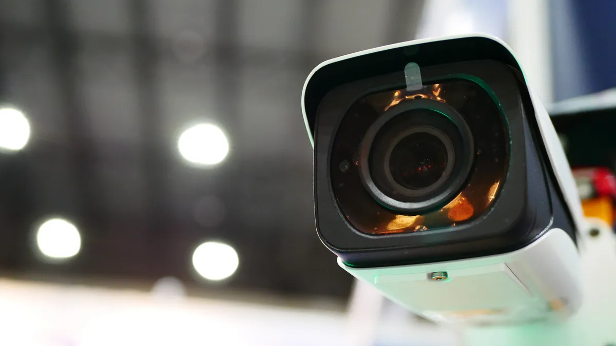 A security camera hangs in a hallway.