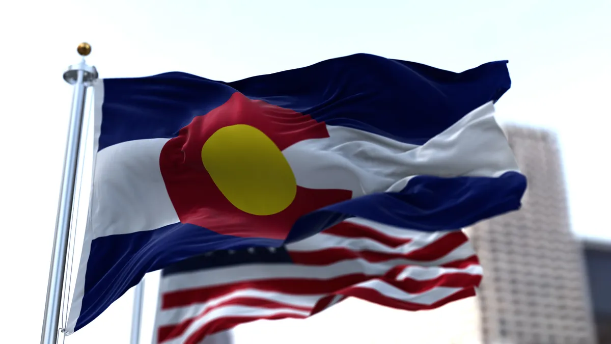 The Colorado flag waves in the breeze in front of an American flag.