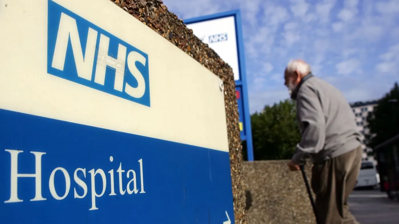 An elderly gentleman walks past a hospital sign on September 26, 2007 in London, England. In a report to be released September 27, 2007 the Healthcare Commission outlines care by the NHS Trust should provide further dignity in care to the elderly.