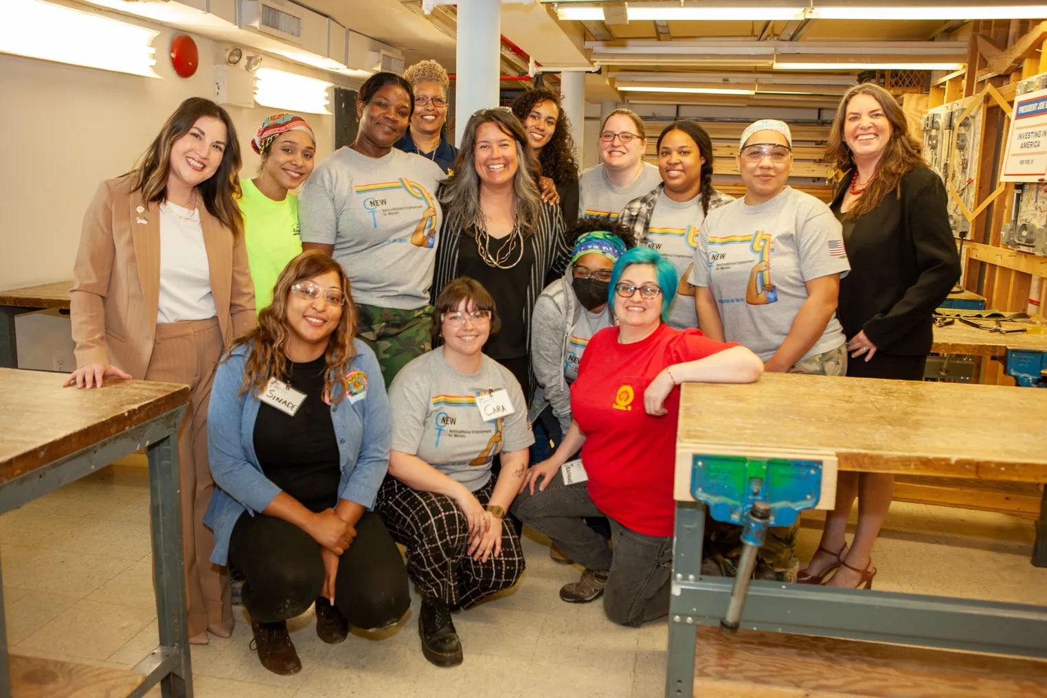 A group of women pose for a photo in a carpentry workshop.