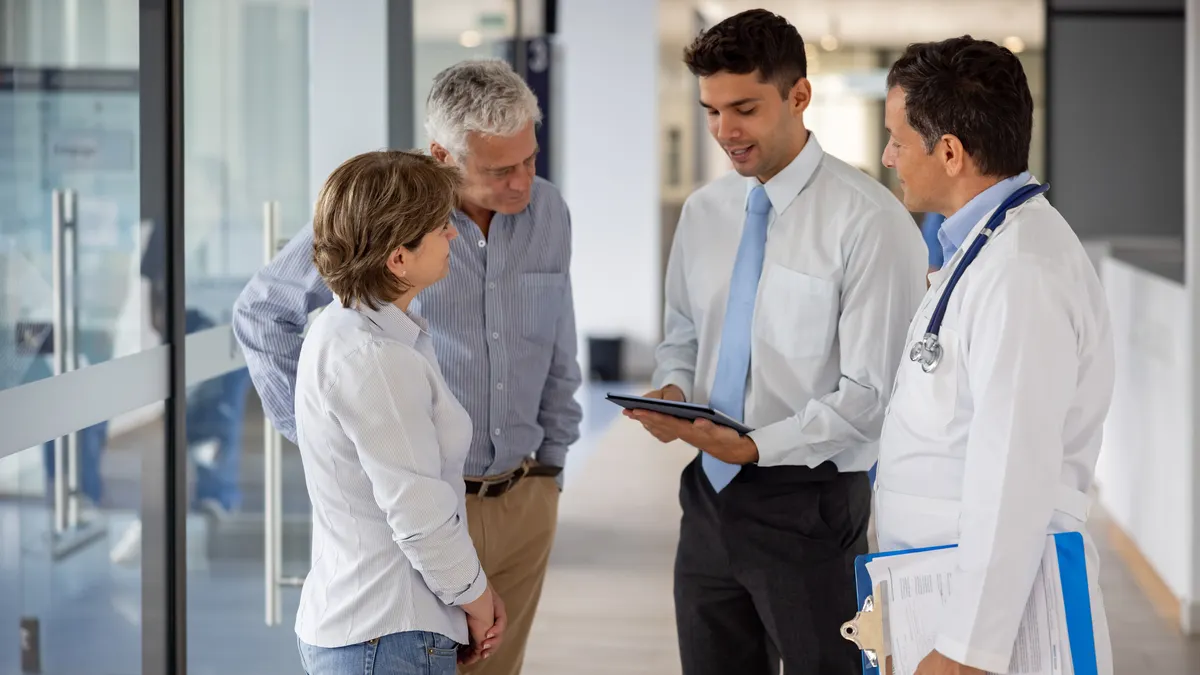 Doctor and patients talking to the hospital manager about their health insurance coverage.
