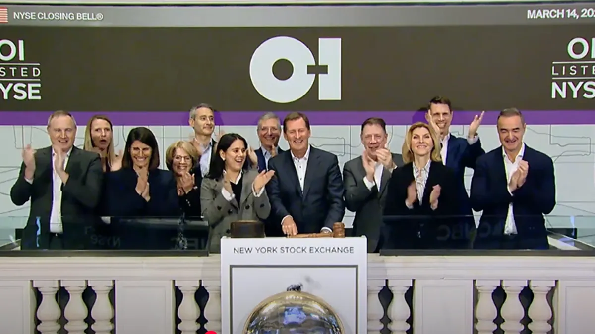 O-I Glass leaders stand and cheer as they ring the New York Stock Exchange closing bell