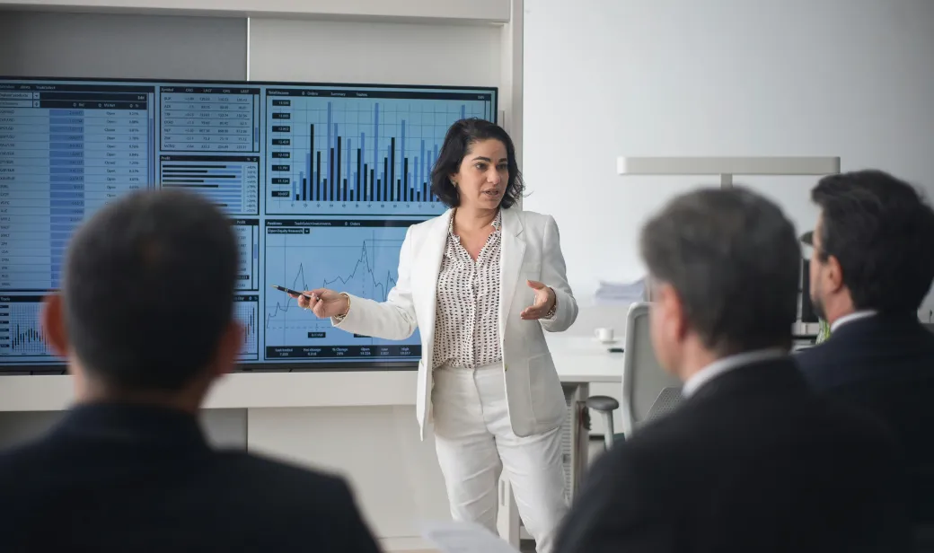 Woman presenting with charts behind her.