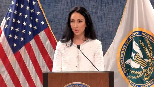 A woman speaks from a podium.