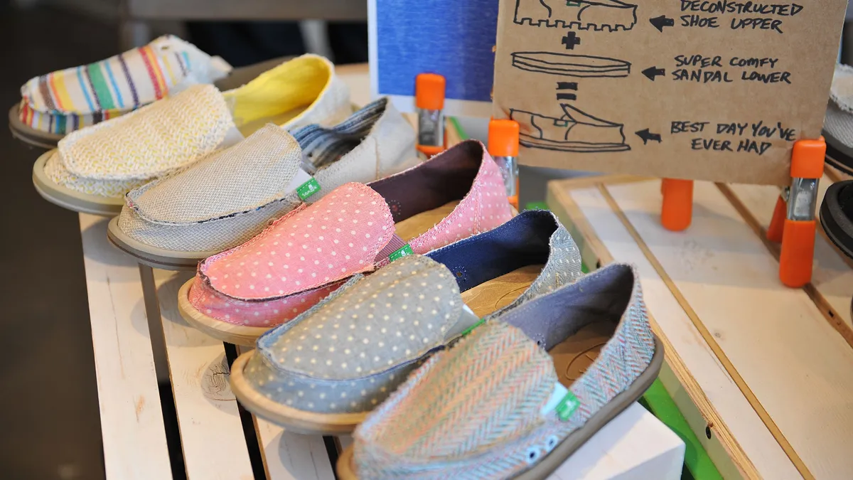 A close up of a store display of Sanuk shoes. Individual shoes in patterns such as polka dots and stripes are pictured next to each other.