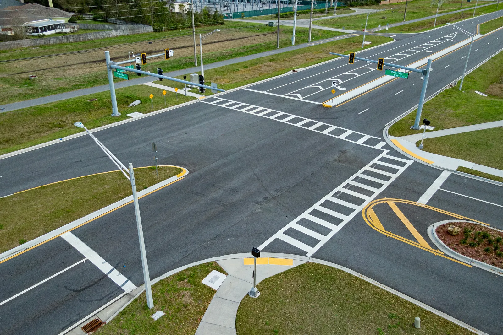 An overhead view of a newly-constructed intersection in Jacksonville, Florida with brightly marked crosswalks and overhead traffic signals.