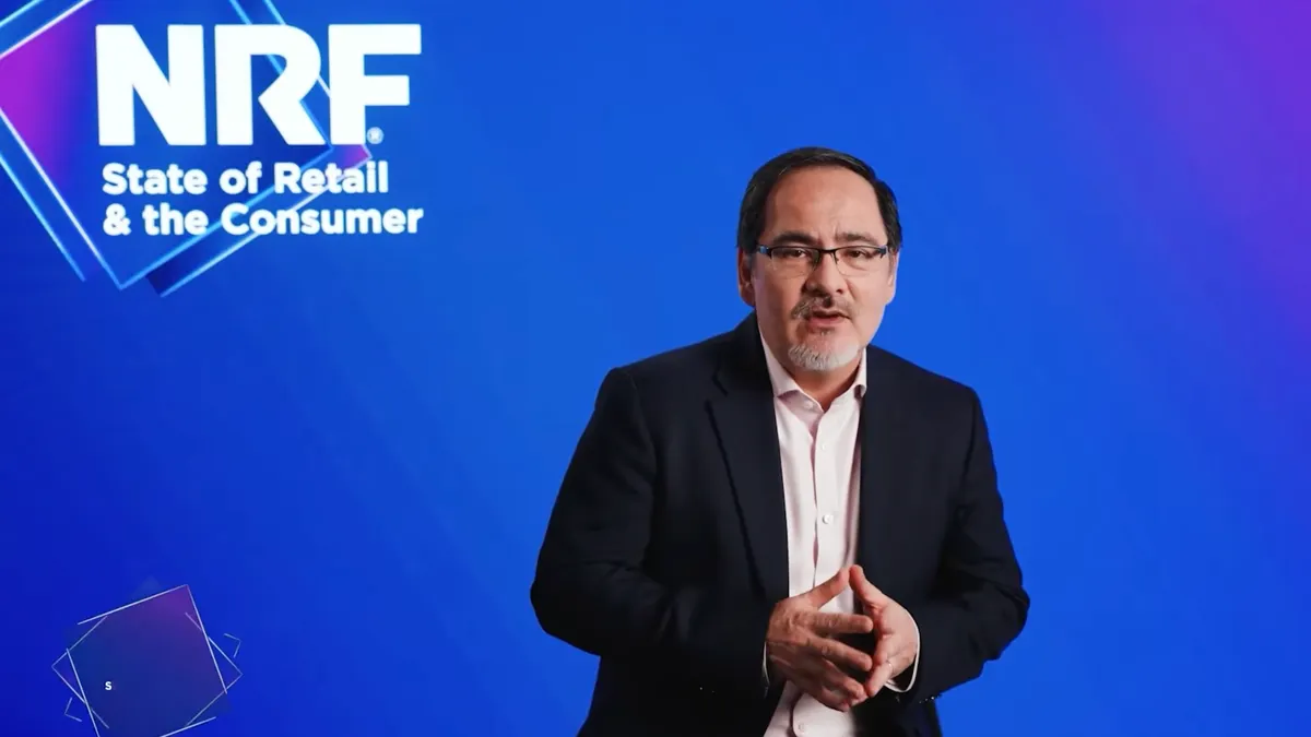 A person with glasses wearing a dark jacket.