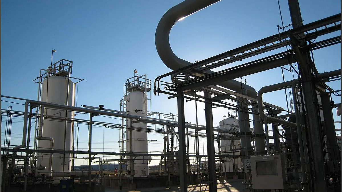 A series of large interconnected pipes and tanks at an industrial facility on a concrete pad.