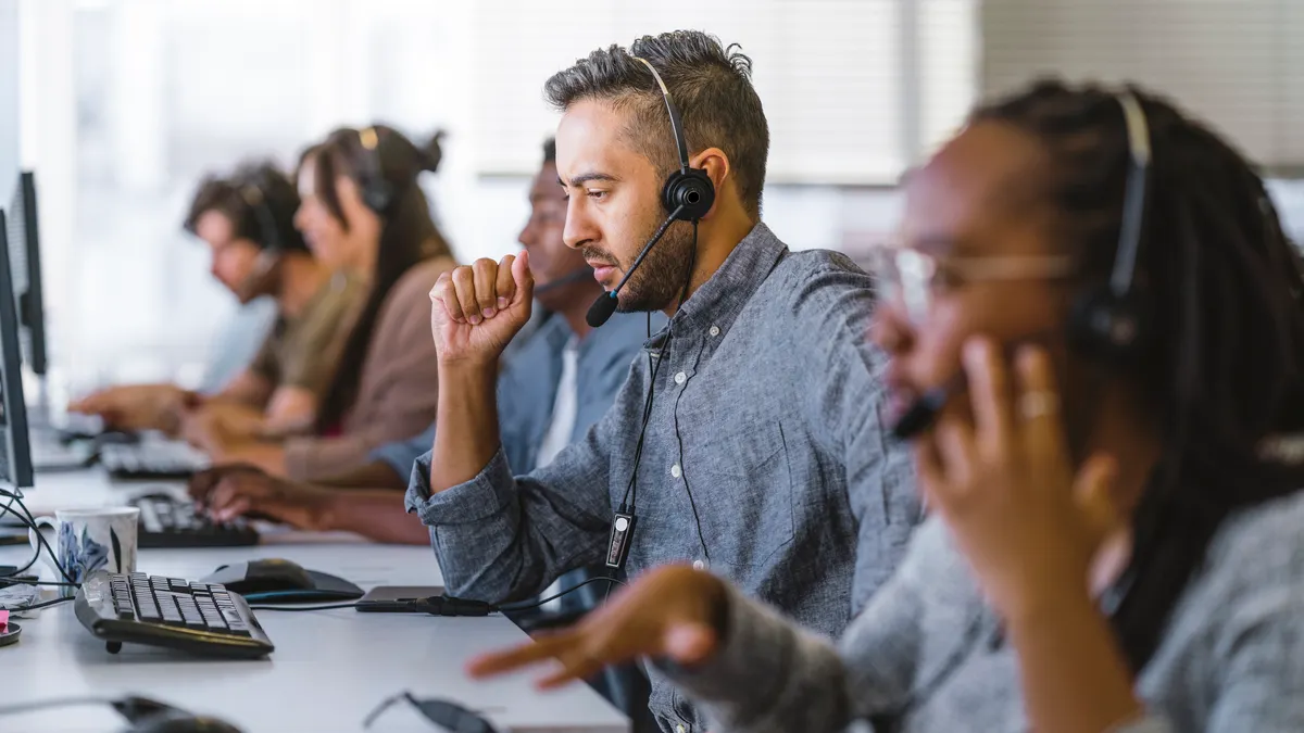 Contact center agents work in a row at call center.