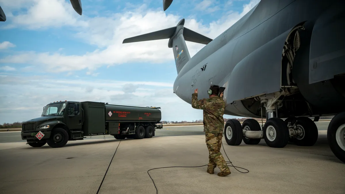 R-11 Refueler next to a C-5M Super Galaxy on a air force tarmac.