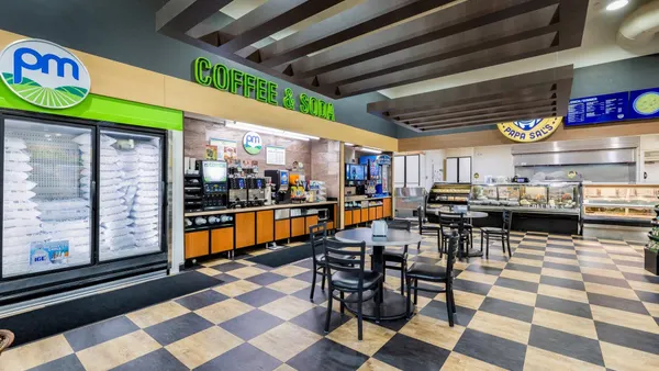 A photo of the interior of a convenience store, designed with a blue and green color scheme. Signs say PM, Coffee & soda, and Papa Sal's.
