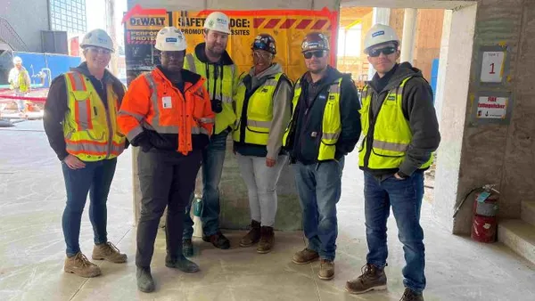 A group of construction workers stand together on a jobsite