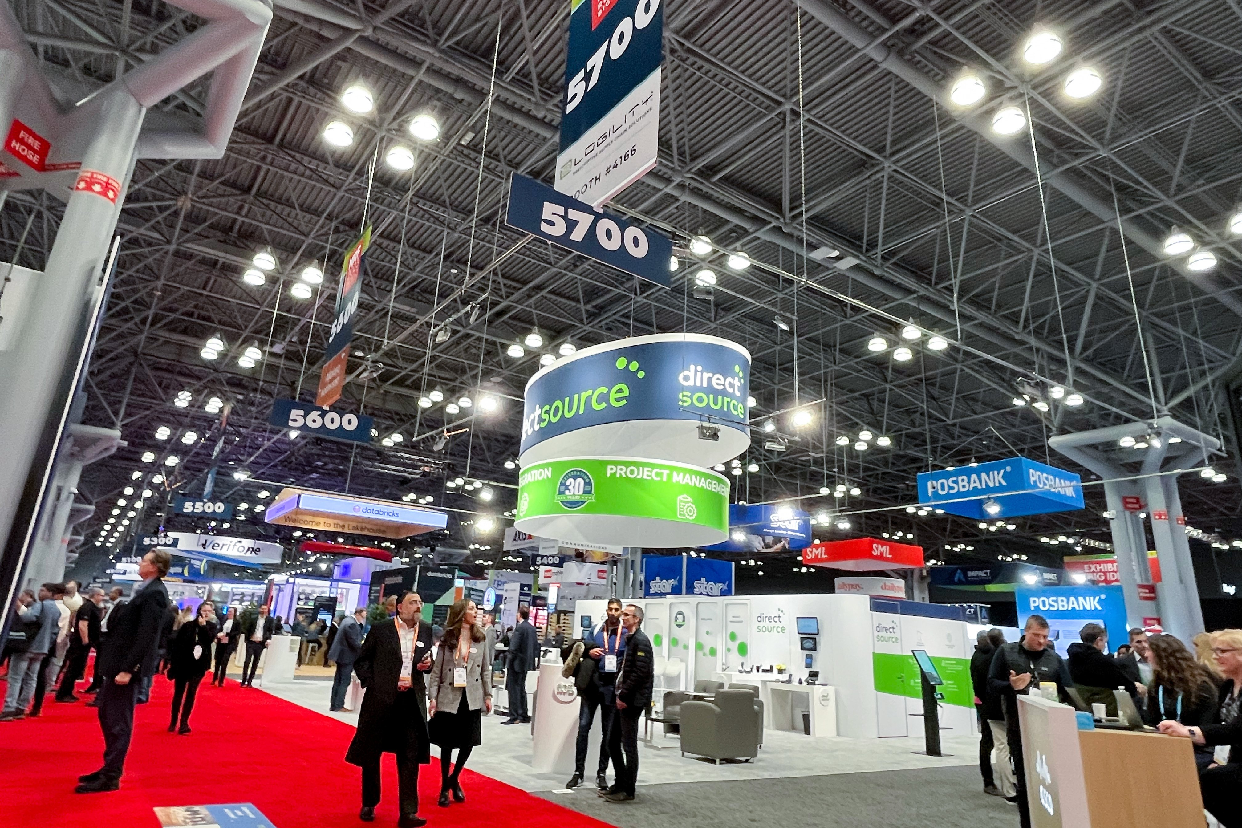 An exhibition floor at a conference filled with vendor booths and people
