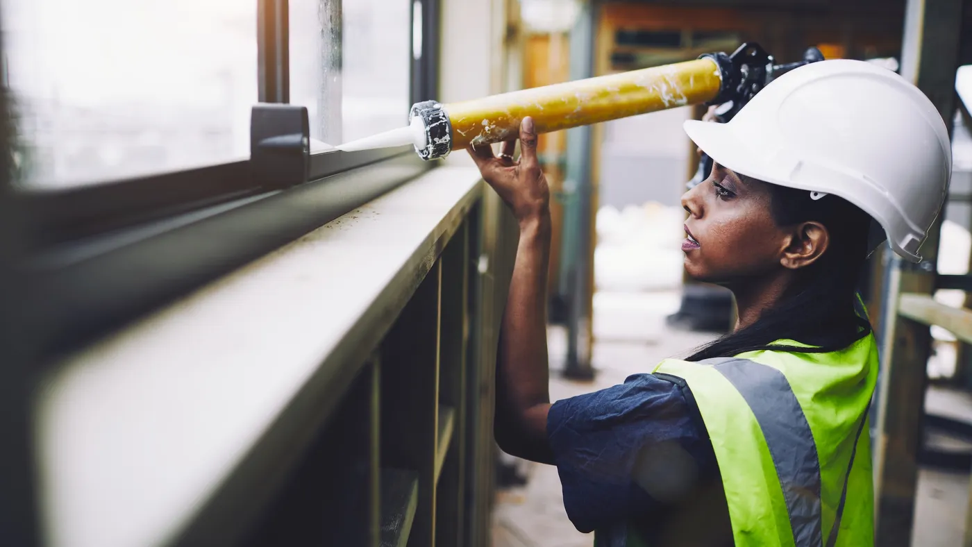 A woman construction worker of color works on a jobsite.