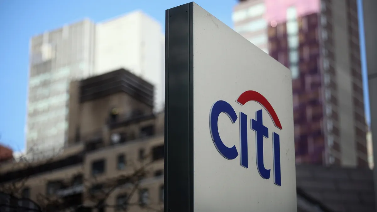 A sign in the foreground reads "Citi" with buildings in the background.