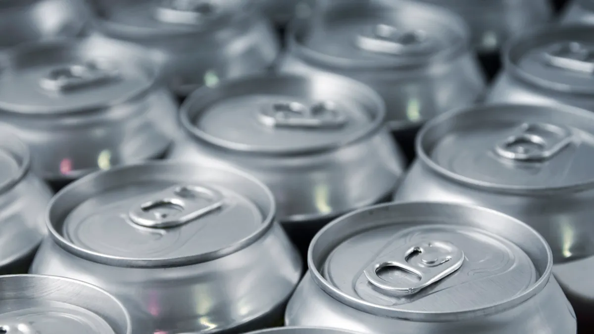 The tops of silver tabbed beverage cans