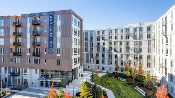 Mid-rise apartments surrounding grass courtyard.