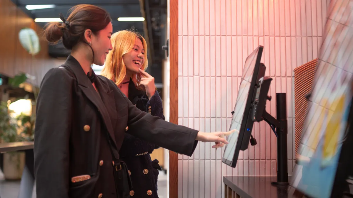 Image of two customers browsing display screen