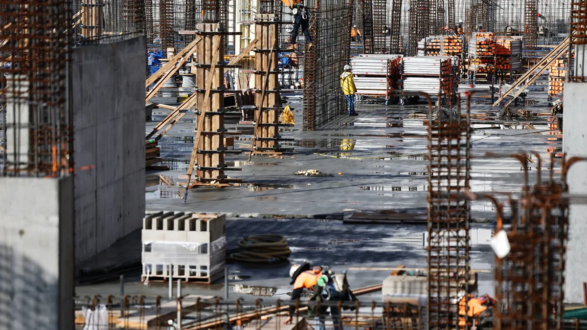 Construction workers help build a mixed-use apartment complex which will hold over 700 units of apartment housing and 95,000 square feet of commercial space on January 25, 2024 in Los Angeles