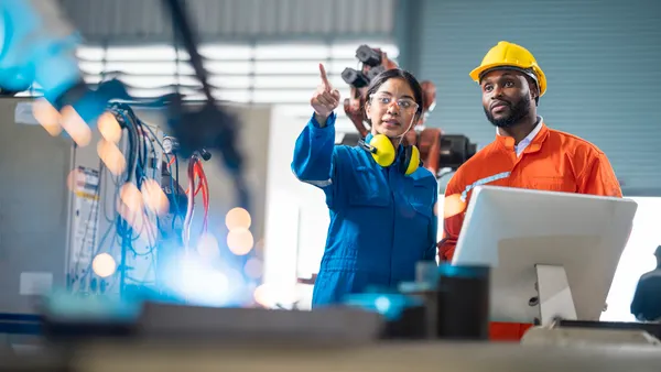 Female engineer presentation robotic welding process to her team in testing area of research and development. Production process improvement concepts.