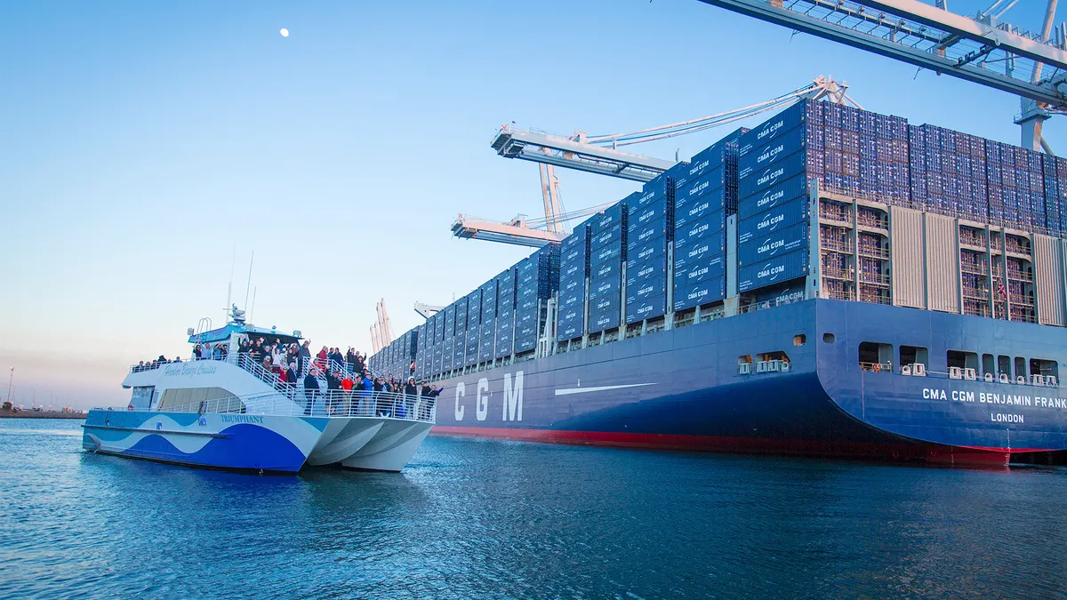 A containership full of containers next to a tour boat full of passengers.