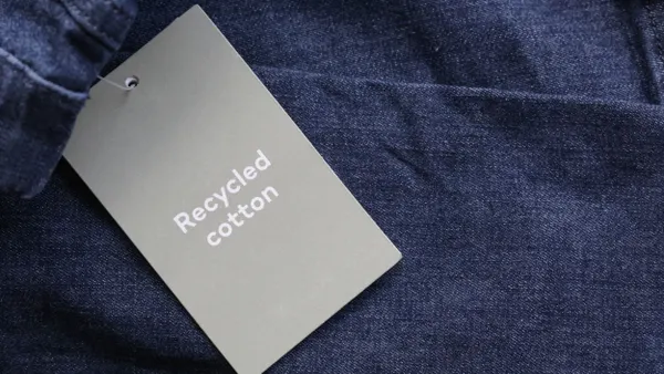 Close up of clothing hang tag. Recycled cotton product details.