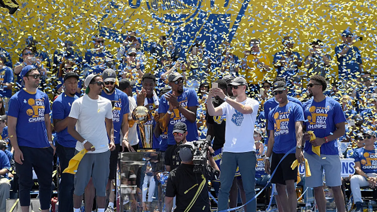 The Golden State Warriors in front of a celebrating crowd