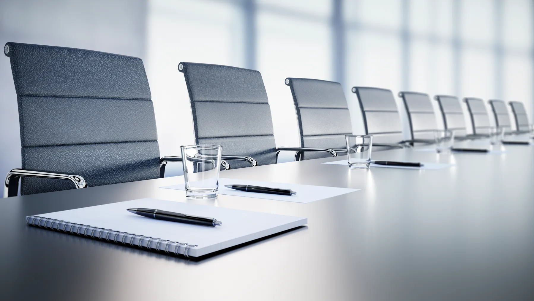 Close up of a large conference table with chairs in a meeting room in the high-rise office building