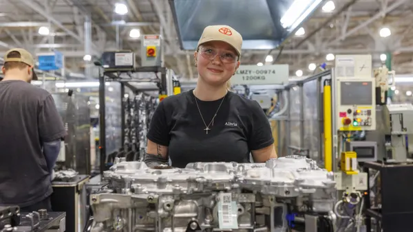 A production worker poses for a photo at a Toyota engine plant.