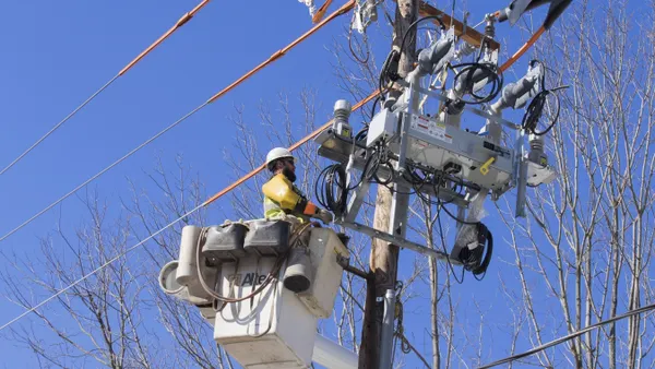 An electric utility lineman works on a power line.