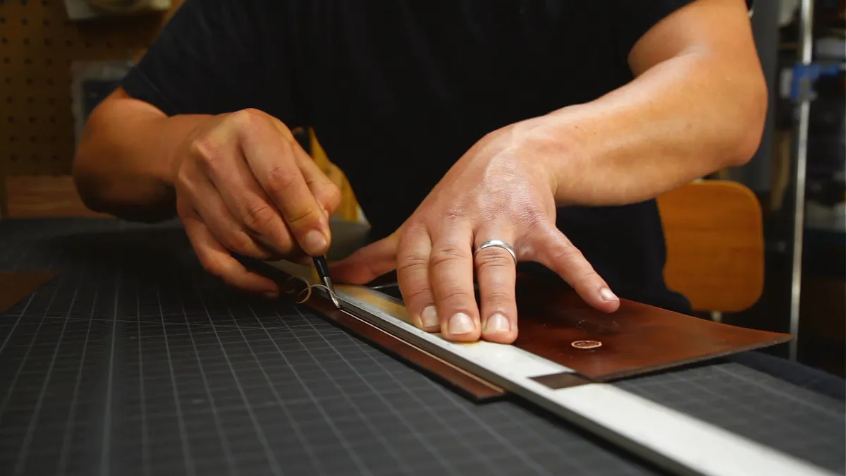 A person crafting leather goods.