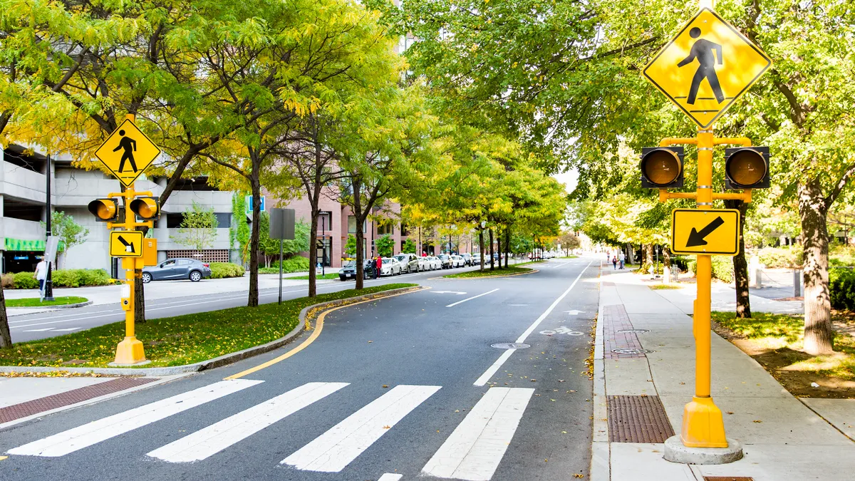 A pedestrian crossing with traffic lights and signs.