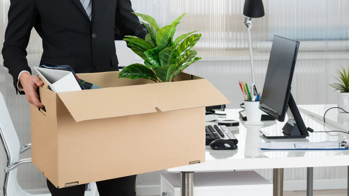 Executive carries out box in move from office.