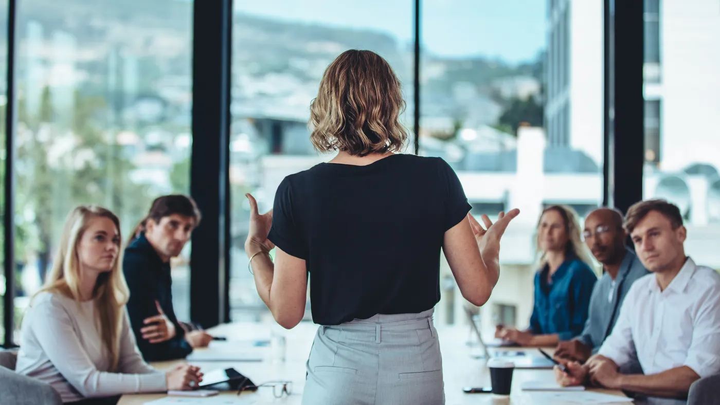 An executive leads a company meeting inside a boardroom