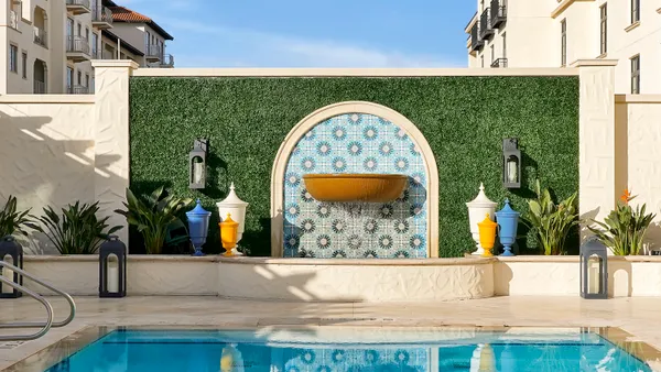 A fountain is seen next to a pool.