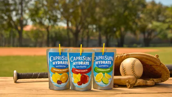 Three Capri Sun Hydrate juice pouches are seen outside with a baseball bat and mit.