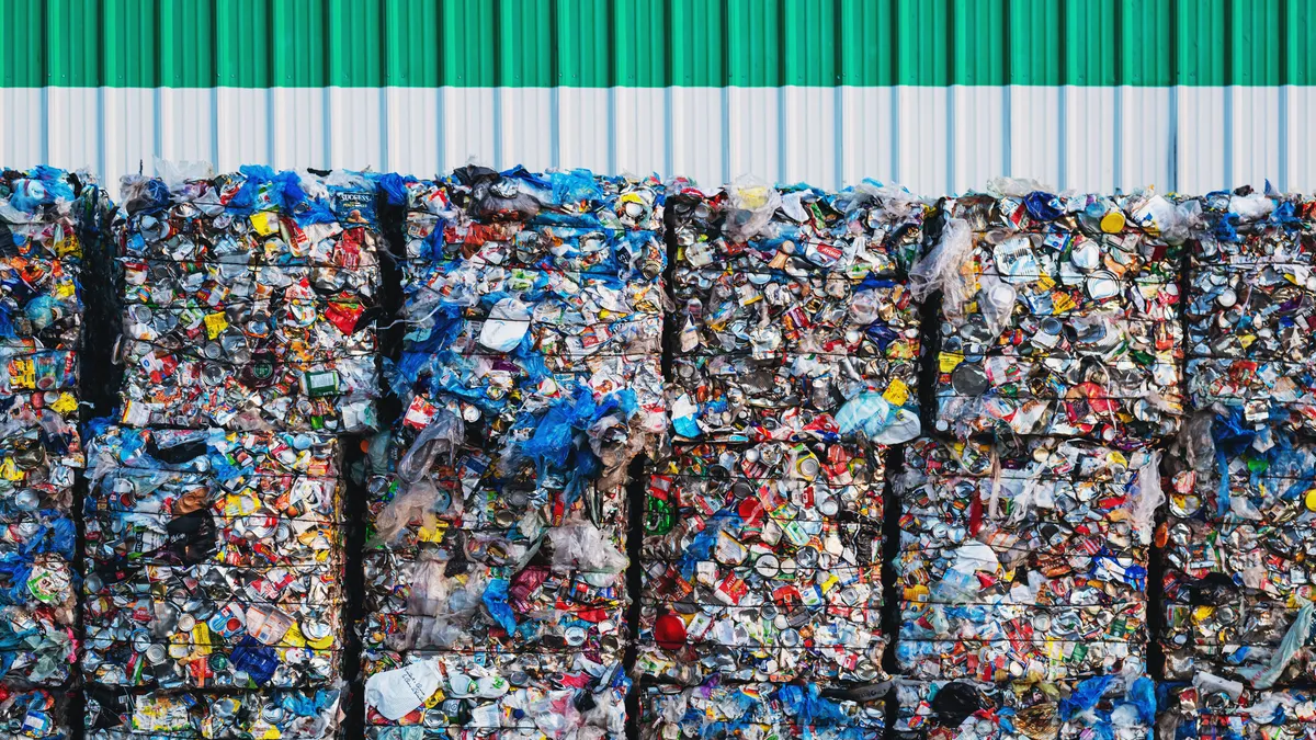 Large bundles of plastic bags, cans and milk containers await processing at a recycling center.