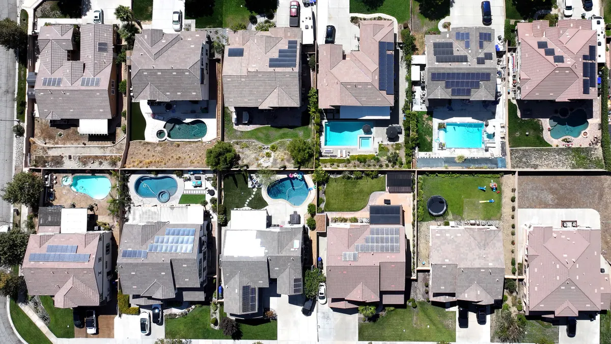 An aerial view of residential homes, many with solar panels.